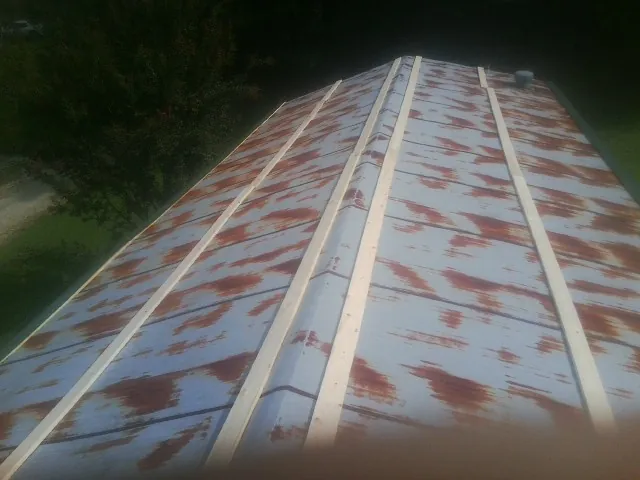 Rusted metal roof panels with new wood purlins before replacement — Storm Damage Roof Repair in Colebrook by Roofing Brothers