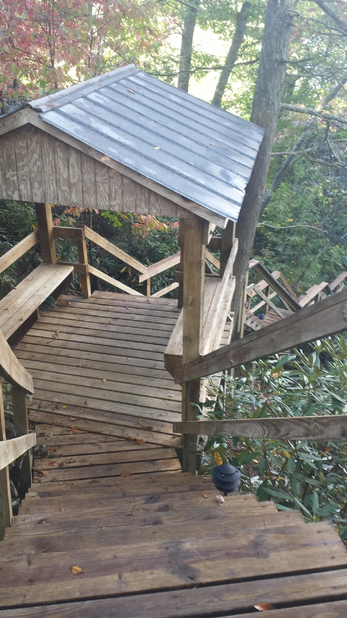Metal roofed shelter over wooden steps on a wooded walkway — Skylight Repair & Installation work by our crew in Colebrook