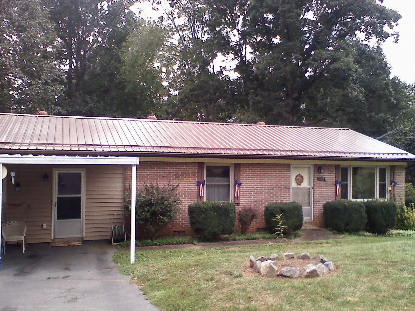 Bronze metal roof and carport on a brick ranch home — Roof Repair work by our crew in Colebrook